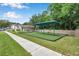 Community playground with artificial turf, covered swing set and perimeter fencing in the residential neighborhood at 3230 Bellericay Ln, Land O Lakes, FL 34638