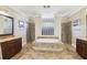 Bright bathroom featuring a soaking tub with tile surround and separate vanities at 3404 W Sevilla St, Tampa, FL 33629