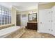 Elegant bathroom boasts a soaking tub, glass block window, and tile shower at 3404 W Sevilla St, Tampa, FL 33629
