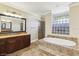 Elegant bathroom boasts a soaking tub, glass block window, and tile shower at 3404 W Sevilla St, Tampa, FL 33629