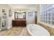 Elegant bathroom boasts a soaking tub, glass block window, and tile shower at 3404 W Sevilla St, Tampa, FL 33629