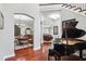 Elegant entryway featuring a grand piano, beautiful wood floors, and archways leading to other rooms at 3404 W Sevilla St, Tampa, FL 33629