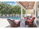 Inviting pool area with beautiful landscaping, a covered patio with ceiling fan, and comfortable seating at 3404 W Sevilla St, Tampa, FL 33629