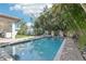 Swimming pool surrounded by palm trees and patio space with an outdoor grilling area at 3404 W Sevilla St, Tampa, FL 33629