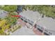 Aerial view of a multi-story tan townhouse, highlighting the unit's private garages and brick paved driveways at 350 2Nd N St # 1, St Petersburg, FL 33701