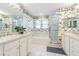 Bright bathroom with double sinks, bathtub, shower, and floral wallpaper at 350 2Nd N St # 1, St Petersburg, FL 33701