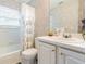 Well-lit bathroom featuring a shower-tub combo, patterned wallpaper, and a single sink vanity at 350 2Nd N St # 1, St Petersburg, FL 33701