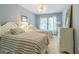 Comfortable bedroom with two twin beds, soft blue walls, and white dresser near a bright window at 350 2Nd N St # 1, St Petersburg, FL 33701