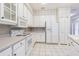 Well-lit kitchen with white cabinets, tile floors, and full-sized appliances at 350 2Nd N St # 1, St Petersburg, FL 33701