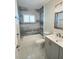 Modern bathroom with shower and tub combo, gray vanity, and tiled walls, providing a stylish and functional space at 3701 Manatee Se Dr, St Petersburg, FL 33705