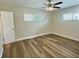 Clean bedroom with two windows, ceiling fan and wood-look flooring at 3701 Manatee Se Dr, St Petersburg, FL 33705