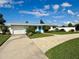 Charming single-story home with blue door, well-maintained lawn, and attached garage at 3701 Manatee Se Dr, St Petersburg, FL 33705