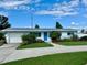 Charming single-story home with blue door, well-maintained lawn, and attached garage at 3701 Manatee Se Dr, St Petersburg, FL 33705