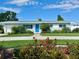 Charming single-story home with blue door, well-maintained lawn, and beautiful landscaping at 3701 Manatee Se Dr, St Petersburg, FL 33705