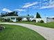 Well-manicured front yard with lush lawn and a single-story home with a white fence at 3701 Manatee Se Dr, St Petersburg, FL 33705