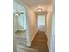 Bright hallway with wood flooring leading to rooms with ceiling fans, offering a seamless transition in the home's layout at 3701 Manatee Se Dr, St Petersburg, FL 33705