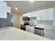 Modern kitchen featuring white cabinets, stainless steel appliances, and a stylish breakfast bar with marble countertops at 3701 Manatee Se Dr, St Petersburg, FL 33705
