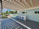 Outdoor patio area with an overhead pergola, a bar with stools, and backyard views at 3701 Manatee Se Dr, St Petersburg, FL 33705