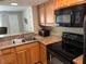 Well-equipped kitchen featuring granite countertops and black appliances for cooking convenience at 3814 N Lake Dr # 65, Tampa, FL 33614