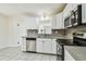 Well-lit kitchen featuring stainless steel appliances, white cabinets and gray countertops at 3818 Grove S St, St Petersburg, FL 33705