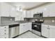 Well-lit kitchen featuring stainless steel appliances, white cabinets and gray countertops at 3818 Grove S St, St Petersburg, FL 33705