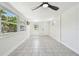 Spacious sunroom with ample natural light, tile flooring, and a modern ceiling fan fixture at 3818 Grove S St, St Petersburg, FL 33705