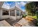 Charming backyard featuring a patio area, white exterior of the home, lush greenery, and a seating area at 4229 Glissade Dr, New Port Richey, FL 34652