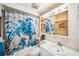 Bright bathroom featuring a tub with a decorative turtle-themed curtain and a well-lit vanity at 4229 Glissade Dr, New Port Richey, FL 34652