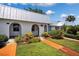 Charming home exterior with a metal roof, beautiful landscaping, and a walkway leading to the entrance at 4229 Glissade Dr, New Port Richey, FL 34652