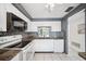 Well-lit kitchen showcasing white cabinetry, granite countertops, mosaic tile backsplash, and modern appliances at 4229 Glissade Dr, New Port Richey, FL 34652