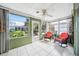Relaxing sunroom with white tile, large windows, ceiling fan, and comfortable wicker chairs at 4229 Glissade Dr, New Port Richey, FL 34652