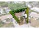 Aerial view of a property surrounded by greenery, featuring a driveway with multiple vehicles parked at 4411 W Bay Villa Ave, Tampa, FL 33611