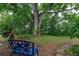 Inviting backyard featuring a blue bench and lush greenery under a large shade tree at 4411 W Bay Villa Ave, Tampa, FL 33611