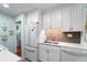 Modern kitchen with white cabinetry, stainless steel appliances, and a stylish tile backsplash at 4411 W Bay Villa Ave, Tampa, FL 33611