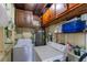 A functional laundry room with a washer, dryer, water heater, and storage shelves at 4411 W Bay Villa Ave, Tampa, FL 33611