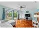 Bright living room with hardwood floors, large windows offering beautiful backyard views, and a white sofa at 4411 W Bay Villa Ave, Tampa, FL 33611