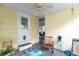 A covered patio featuring a door, a rocking chair, and ceiling fan provides relaxation and outdoor living at 4411 W Bay Villa Ave, Tampa, FL 33611