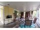A large screened patio with a dining table, chairs, a TV, and other decorations for outdoor entertainment at 4411 W Bay Villa Ave, Tampa, FL 33611
