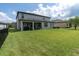 Expansive backyard features a covered patio and lush green lawn, perfect for outdoor entertaining at 4496 Tatum Loop, Odessa, FL 33556