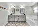 Bathroom featuring a double vanity, modern mirrors, patterned flooring, and a soaking tub at 4496 Tatum Loop, Odessa, FL 33556