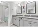 Bathroom with double sinks, granite countertops, framed mirrors, and modern lighting fixtures at 4496 Tatum Loop, Odessa, FL 33556