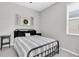 Neutral bedroom featuring a bed with black metal frame and window with shutter decor at 4496 Tatum Loop, Odessa, FL 33556
