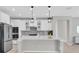 Bright kitchen features white cabinetry, stainless steel appliances, a large island, and pendant lighting at 4496 Tatum Loop, Odessa, FL 33556