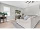 Cozy living room with light wood floors, a comfortable sectional sofa, and a media center with TV at 4496 Tatum Loop, Odessa, FL 33556
