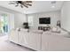Bright living room featuring a large sectional sofa, ceiling fan, and sliding glass doors to the outside at 4496 Tatum Loop, Odessa, FL 33556