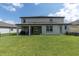 View of home's rear exterior showcasing a large yard, patio and access to outdoor living spaces at 4496 Tatum Loop, Odessa, FL 33556