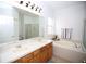 Bathroom features double sink vanity, soaking tub, large mirror and glass enclosed shower at 4535 Gateway Blvd, Wesley Chapel, FL 33544