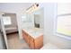 Bright bathroom featuring a double sink vanity and a large mirror with views into the bedroom at 4535 Gateway Blvd, Wesley Chapel, FL 33544