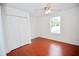 This bedroom features wood floors, a ceiling fan, and a double door closet at 4535 Gateway Blvd, Wesley Chapel, FL 33544