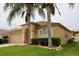 Charming single-story home with a well-manicured lawn and beautiful landscaping with lush, mature palm trees at 4535 Gateway Blvd, Wesley Chapel, FL 33544